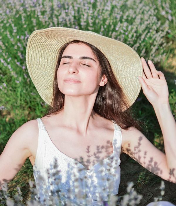Woman closing eyes and smiling gently in a bright room
